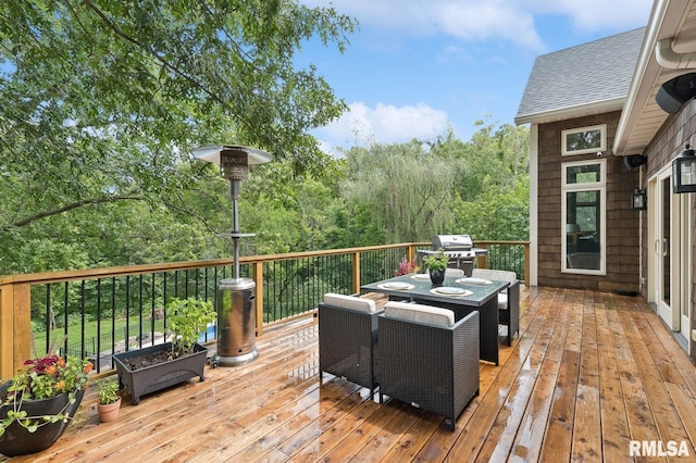 27998 229th St, Le Claire, IA 52753 - deck featuring a grill, outdoor dining space, and a forest view