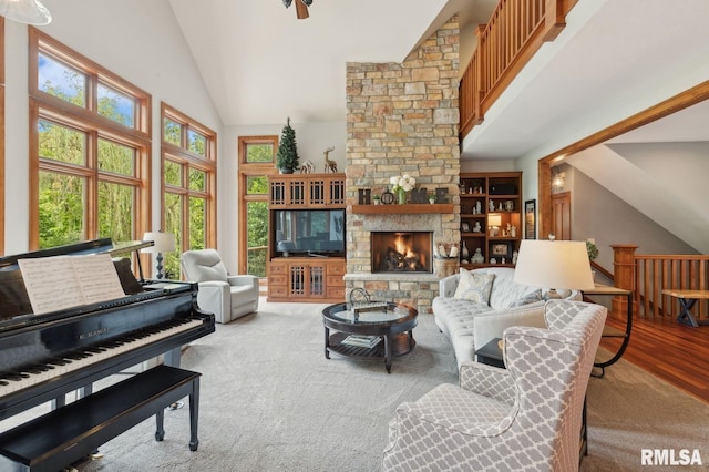 27998 229th St, Le Claire, IA 52753 - living area featuring high vaulted ceiling, a stone fireplace, and wood finished floors