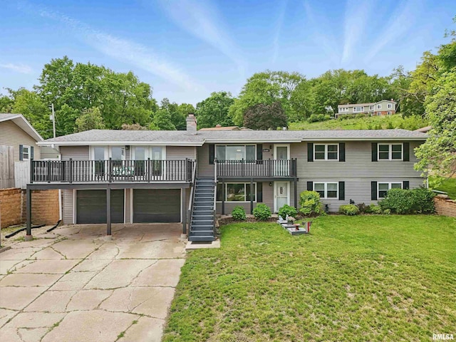 21704 283rd Ave, Le Claire, IA 52753 - view of front of house with a front yard, stairway, a garage, concrete driveway, and a chimney