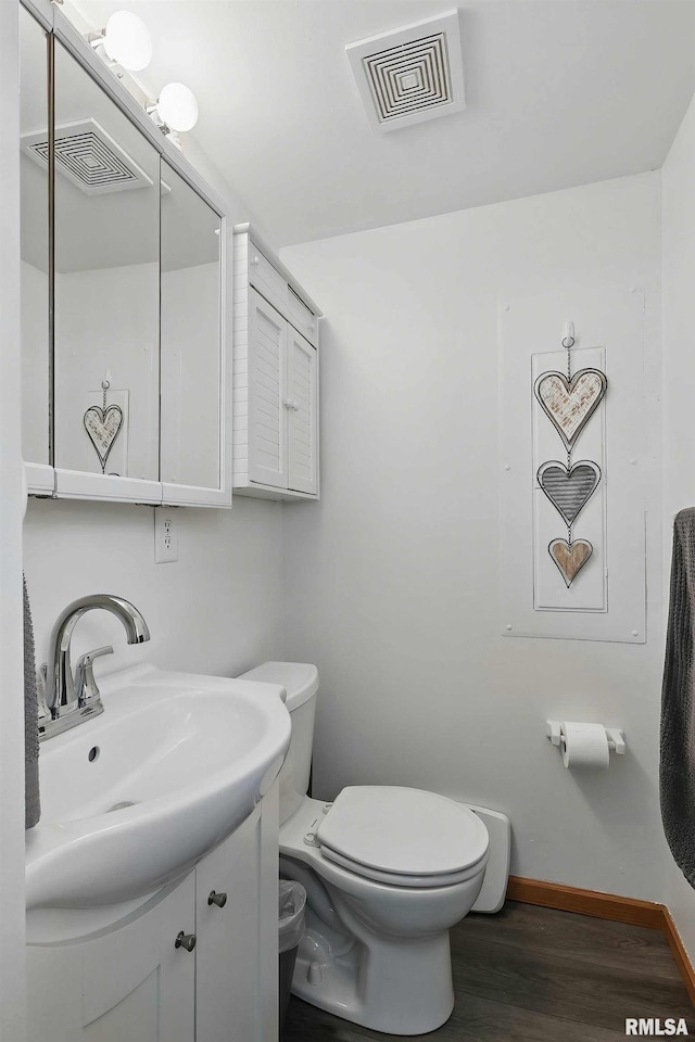 21704 283rd Ave, Le Claire, IA 52753 - bathroom featuring wood finished floors, vanity, toilet, and baseboards
