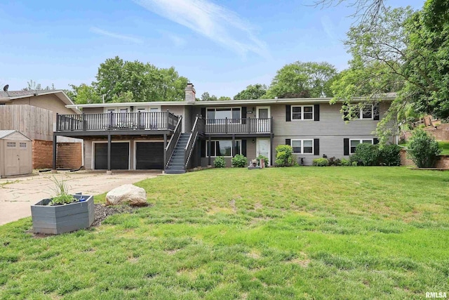 21704 283rd Ave, Le Claire, IA 52753 - rear view of property with a chimney, a wooden deck, driveway, a yard, and an attached garage