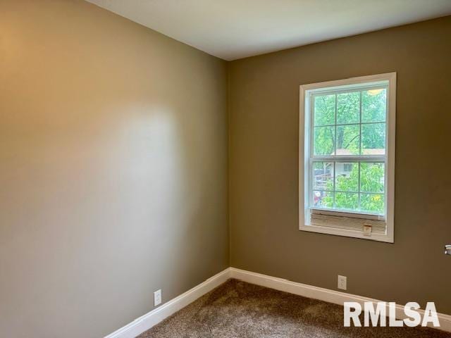 1203 13th Ave S, Clinton, IA 52732 - spare room featuring baseboards and dark colored carpet