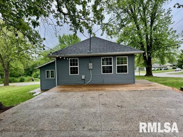 1203 13th Ave S, Clinton, IA 52732 - back of house with roof with shingles, a yard, and asphalt driveway