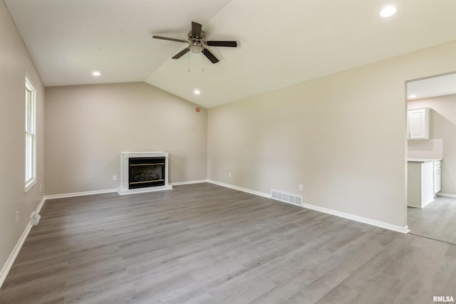 301 5th St, Matherville, IL 61263 - unfurnished living room with a ceiling fan, recessed lighting, a glass covered fireplace, baseboards, and light wood-style floors