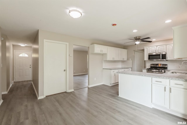 301 5th St, Matherville, IL 61263 - kitchen with appliances with stainless steel finishes, a sink, ceiling fan, tasteful backsplash, and baseboards