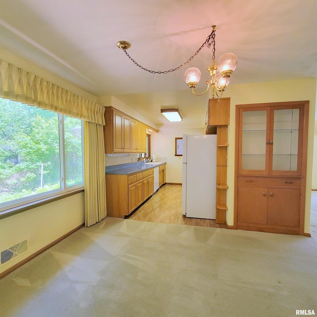 2727 32nd Avenue Ct, Rock Island, IL 61201 - kitchen with white appliances, light colored carpet, baseboards, a chandelier, and a sink