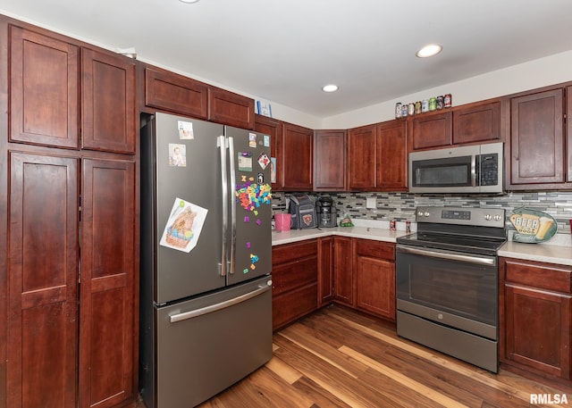2908 N 4th St, Clinton, IA 52732 - kitchen with appliances with stainless steel finishes, light countertops, wood finished floors, decorative backsplash, and recessed lighting