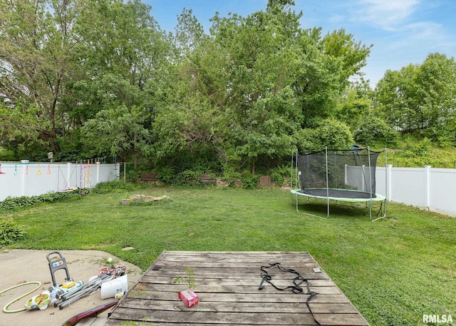 2908 N 4th St, Clinton, IA 52732 - view of yard featuring a trampoline, a wooden deck, and view of wooded area