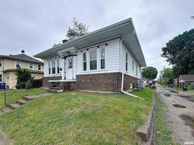 308 E Central Park Ave, Davenport, IA 52803 - view of front of home featuring brick siding, a front yard, and central AC