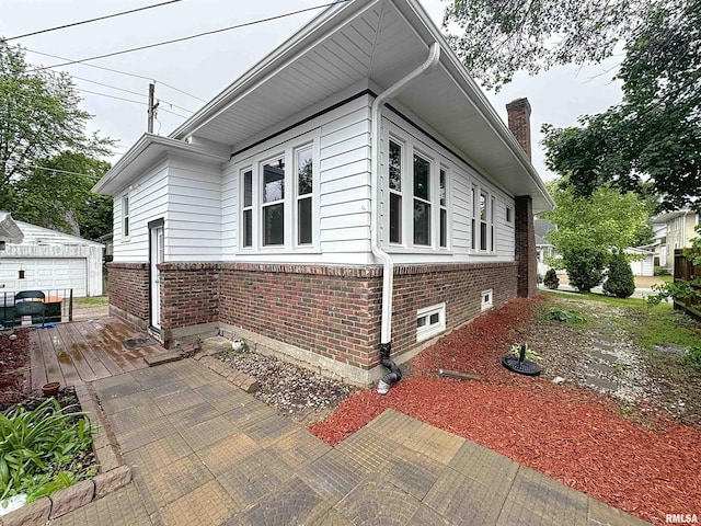 308 E Central Park Ave, Davenport, IA 52803 - view of side of home with an outbuilding, brick siding, and a chimney