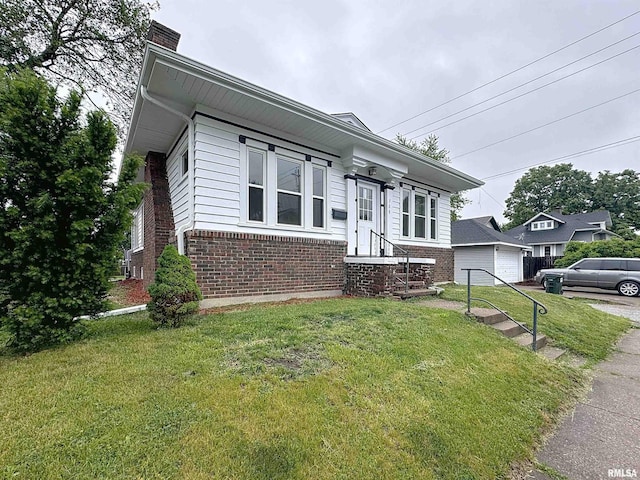 308 E Central Park Ave, Davenport, IA 52803 - view of front of home featuring brick siding, a chimney, a front lawn, and a detached garage