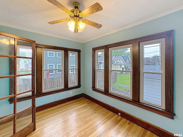 308 E Central Park Ave, Davenport, IA 52803 - unfurnished room with baseboards, light wood finished floors, ceiling fan, and a textured ceiling