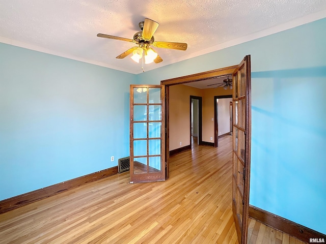 308 E Central Park Ave, Davenport, IA 52803 - unfurnished room with baseboards, light wood-type flooring, ceiling fan, and a textured ceiling