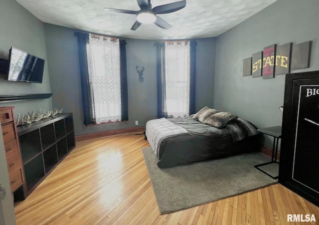 109 W 6th St, Wilton, IA 52778 - bedroom with wood finished floors, ceiling fan, a textured ceiling, and baseboards