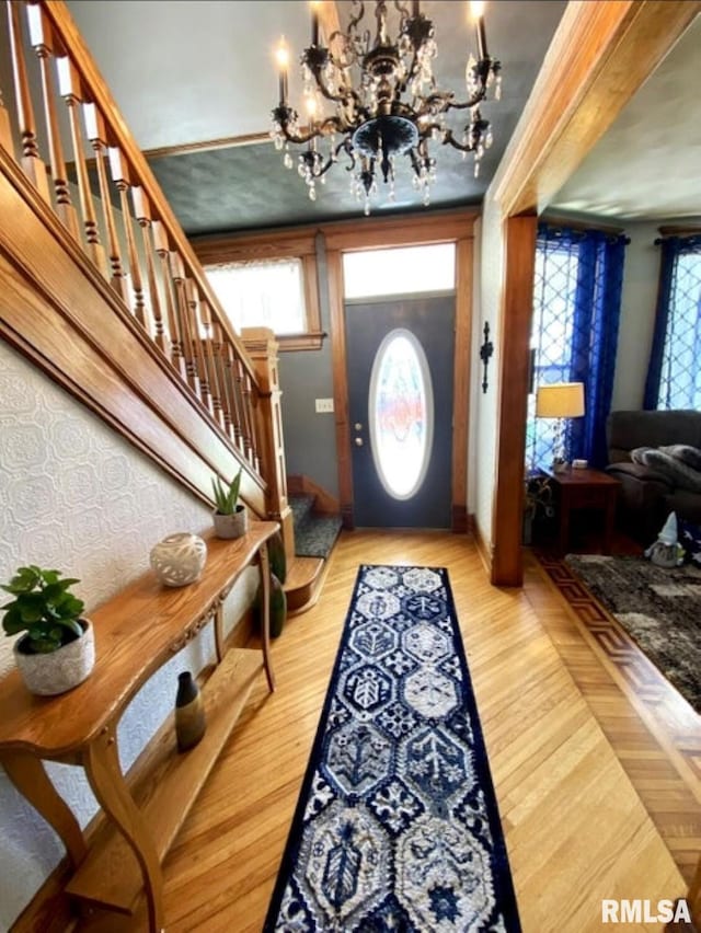 109 W 6th St, Wilton, IA 52778 - entrance foyer with stairs, a chandelier, ornamental molding, baseboards, and light wood-type flooring
