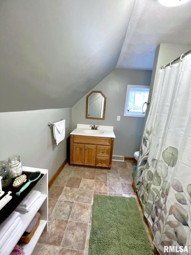 109 W 6th St, Wilton, IA 52778 - full bathroom with lofted ceiling, vanity, toilet, baseboards, and stone finish flooring