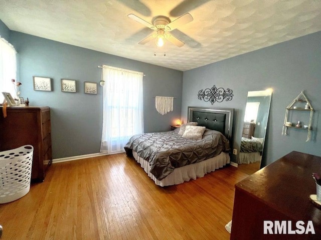 109 W 6th St, Wilton, IA 52778 - bedroom with wood finished floors, a ceiling fan, and baseboards