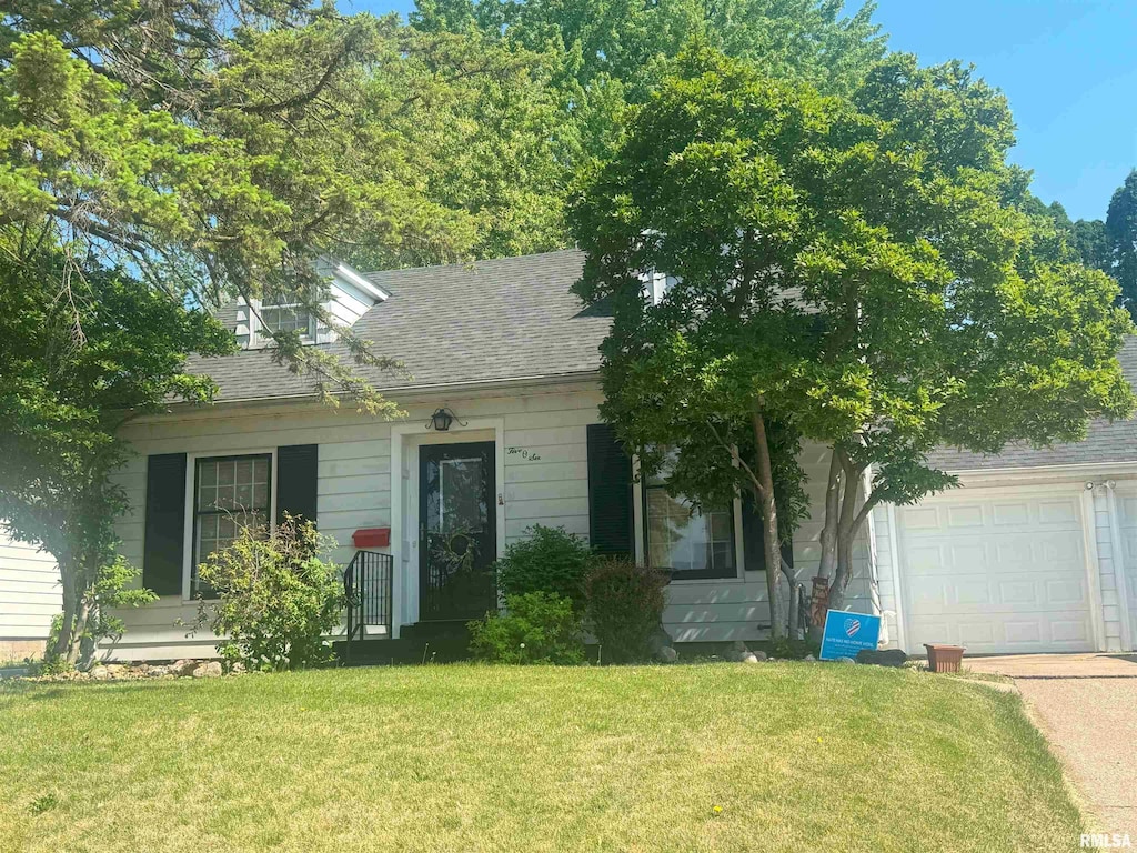 506 15th Ave N, Clinton, IA 52732 - view of front facade featuring a garage, a front lawn, roof with shingles, and driveway