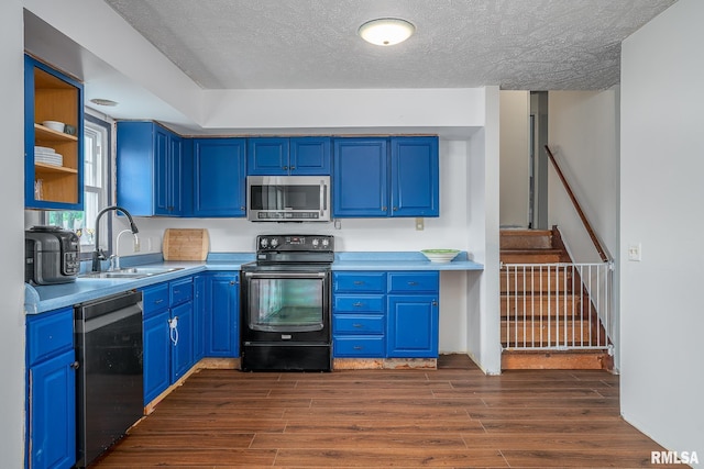 1656 Hitching Post Ln, Davenport, IA 52806 - kitchen with appliances with stainless steel finishes, a sink, blue cabinetry, and a textured ceiling