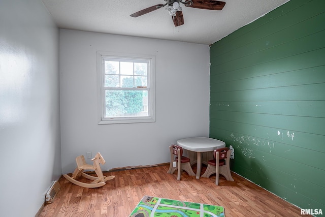 1656 Hitching Post Ln, Davenport, IA 52806 - rec room with wood finished floors, a ceiling fan, and wooden walls