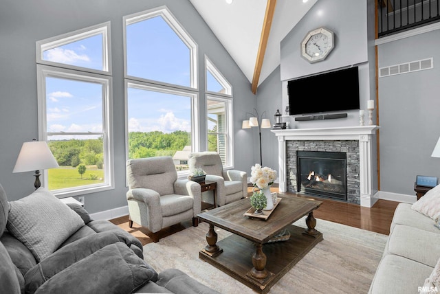 1335 N Utah Ave, Davenport, IA 52804 - living room with a stone fireplace, wood finished floors, baseboards, plenty of natural light, and high vaulted ceiling