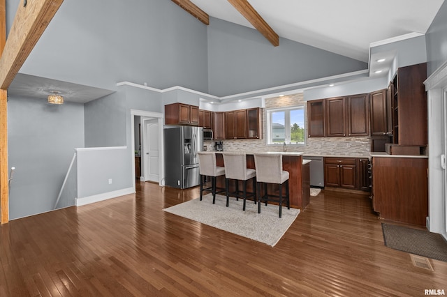 1335 N Utah Ave, Davenport, IA 52804 - kitchen with appliances with stainless steel finishes, tasteful backsplash, light countertops, a kitchen bar, and dark wood-type flooring