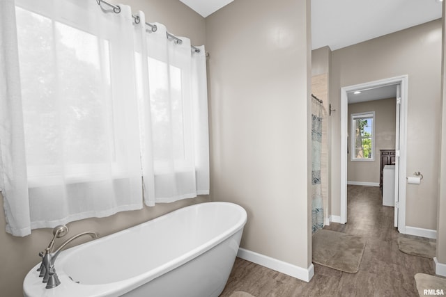 1335 N Utah Ave, Davenport, IA 52804 - bathroom with a freestanding bath, baseboards, wood finished floors, and a shower with shower curtain