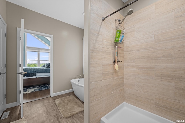 1335 N Utah Ave, Davenport, IA 52804 - bathroom featuring a soaking tub, wood finished floors, tiled shower, and baseboards
