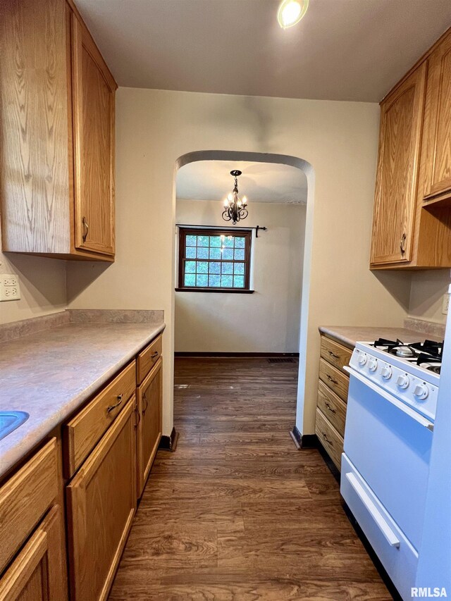 3752 12th St, Rock Island, IL 61201 - kitchen with arched walkways, white range, a chandelier, dark wood-style floors, and light countertops