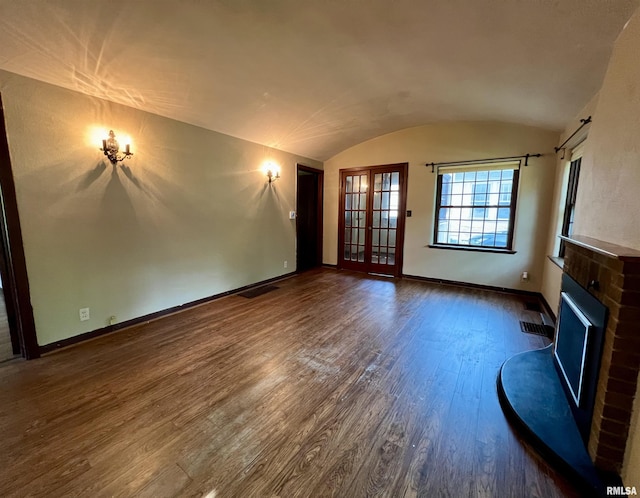 3752 12th St, Rock Island, IL 61201 - unfurnished living room featuring dark wood-style flooring, baseboards, lofted ceiling, and a fireplace