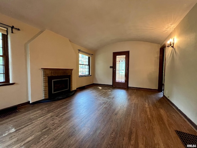 3752 12th St, Rock Island, IL 61201 - unfurnished living room featuring wood finished floors, baseboards, a brick fireplace, and lofted ceiling