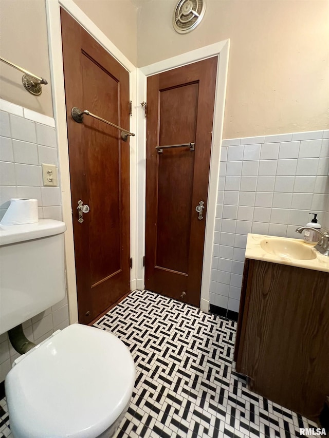 3752 12th St, Rock Island, IL 61201 - bathroom featuring tile walls, vanity, toilet, and wainscoting