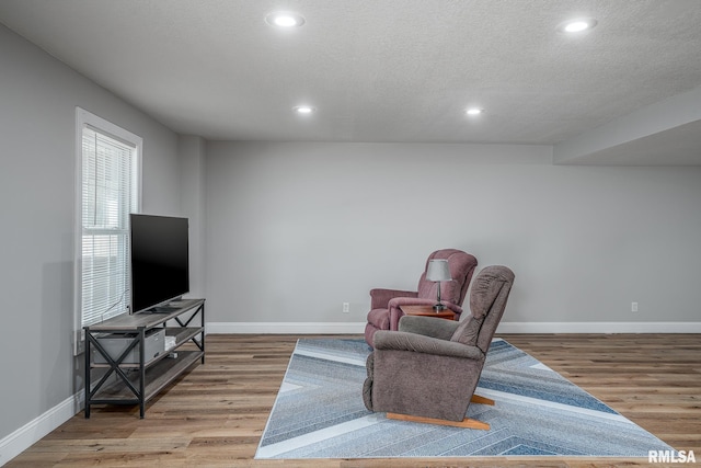 6939 Cresthill Dr, Davenport, IA 52806 - sitting room with wood finished floors, baseboards, recessed lighting, and a textured ceiling