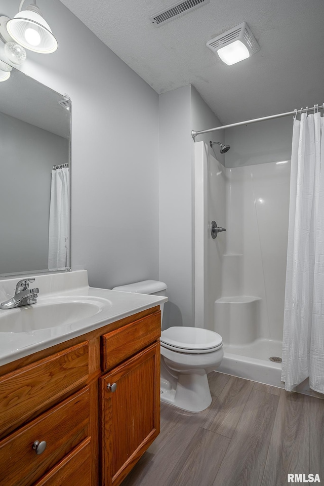 6939 Cresthill Dr, Davenport, IA 52806 - full bathroom featuring vanity, wood finished floors, toilet, and curtained shower