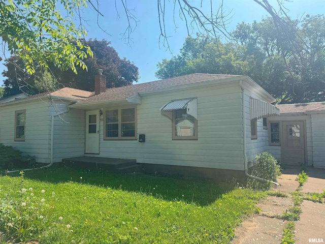 1515 Lazy Ln, Clinton, IA 52732 - view of front of home with a chimney and a front yard