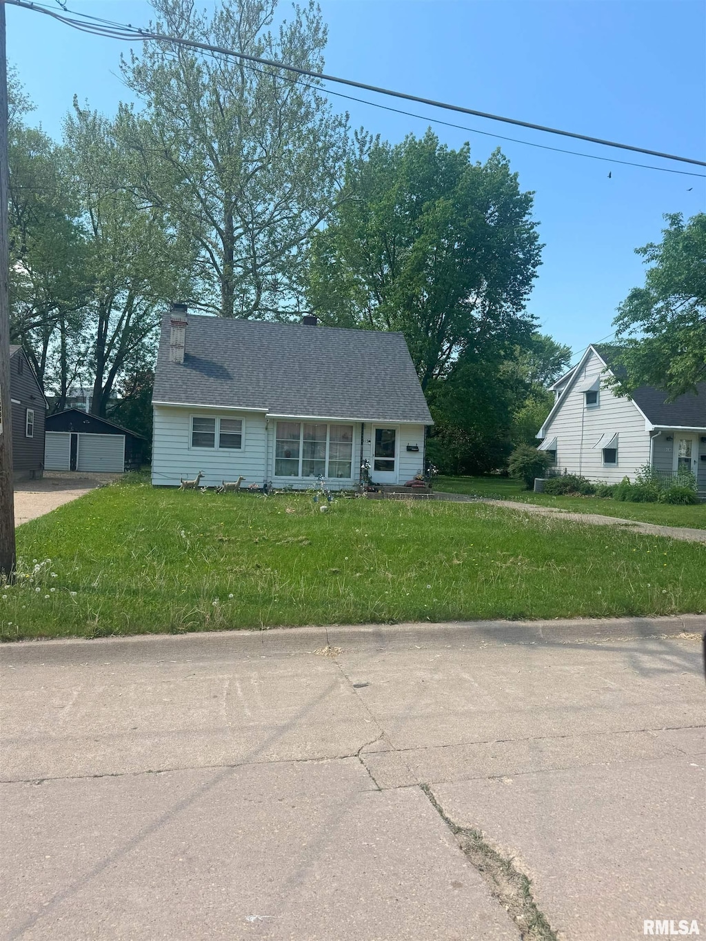 515 16th Ave N, Clinton, IA 52732 - view of front of home featuring a detached garage, a front yard, and a chimney