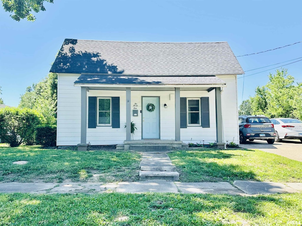 231 Mcneil St, Carterville, IL 62918 - bungalow featuring a porch, a shingled roof, and a front yard