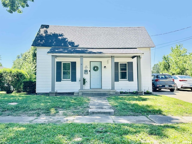 231 Mcneil St, Carterville, IL 62918 - bungalow featuring a porch, a shingled roof, and a front yard
