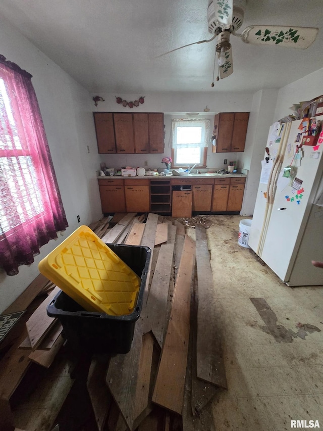 200 Muscatine St, Dixon, IA 52745 - kitchen with freestanding refrigerator, brown cabinetry, ceiling fan, beverage cooler, and light countertops