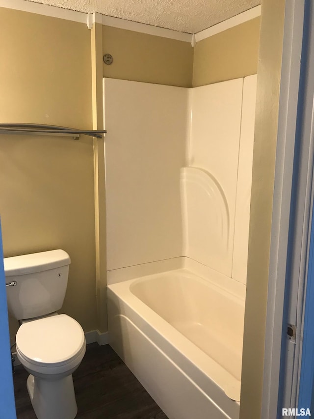 610 E Illinois Ave, Carterville, IL 62918 - full bathroom with a textured ceiling, toilet, wood finished floors, baseboards, and  shower combination
