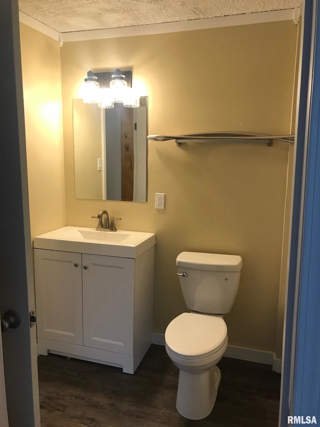 610 E Illinois Ave, Carterville, IL 62918 - half bath featuring wood finished floors, vanity, toilet, a textured ceiling, and baseboards