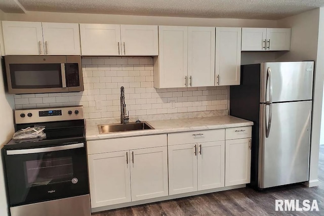 3567 Kimberly Downs Rd, Davenport, IA 52807 - kitchen with stainless steel appliances, a sink, light countertops, white cabinetry, and dark wood finished floors