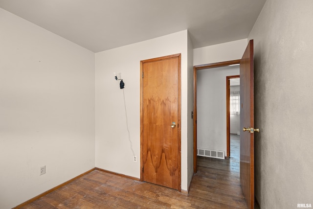 1206 10th Ave N, Clinton, IA 52732 - unfurnished bedroom with wood finished floors and baseboards