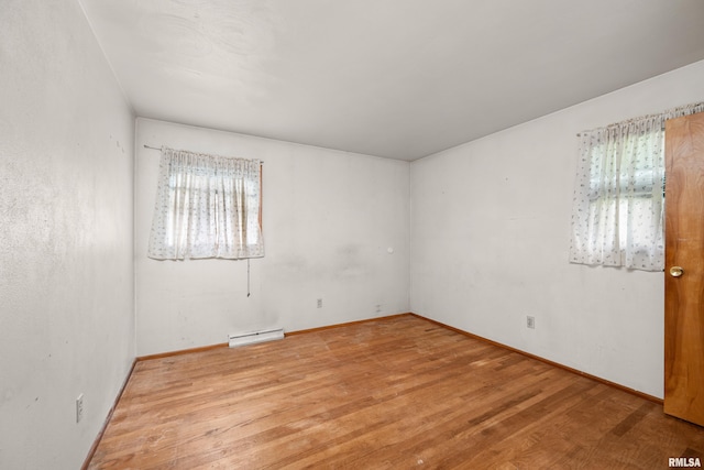 1206 10th Ave N, Clinton, IA 52732 - unfurnished room featuring a baseboard radiator, wood finished floors, and baseboards