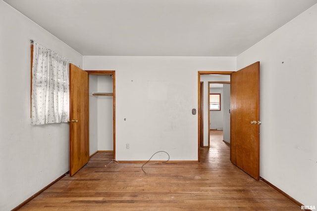 1206 10th Ave N, Clinton, IA 52732 - unfurnished bedroom with wood finished floors, a closet, and baseboards