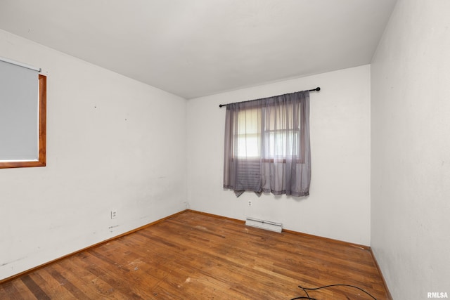 1206 10th Ave N, Clinton, IA 52732 - empty room with a baseboard heating unit, wood finished floors, and baseboards