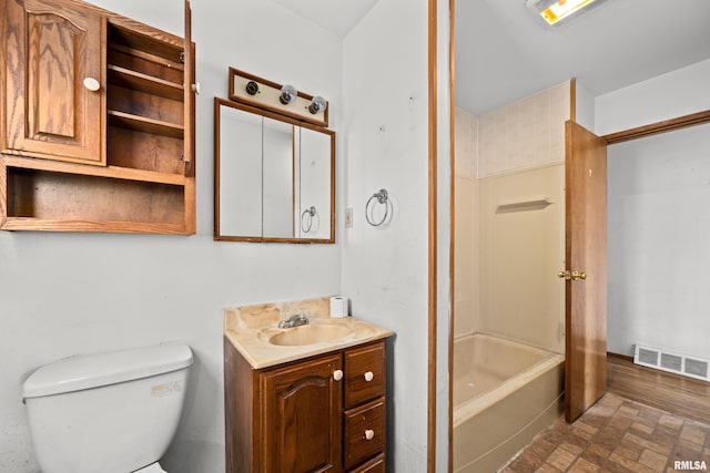 1206 10th Ave N, Clinton, IA 52732 - full bath with vanity, toilet, brick patterned flooring, and shower / washtub combination