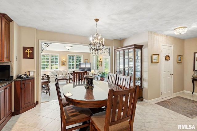 741 12th Ave N, Clinton, IA 52732 - dining area featuring a chandelier, baseboards, and light tile patterned floors