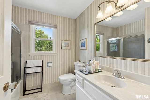 741 12th Ave N, Clinton, IA 52732 - bathroom featuring wallpapered walls, tile patterned floors, vanity, toilet, and shower / bath combination with glass door