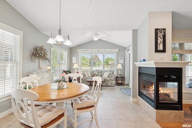 1361 Pinnacle Pines Ct, Bettendorf, IA 52722 - dining area featuring a multi sided fireplace, lofted ceiling, ceiling fan, light tile patterned floors, and baseboards
